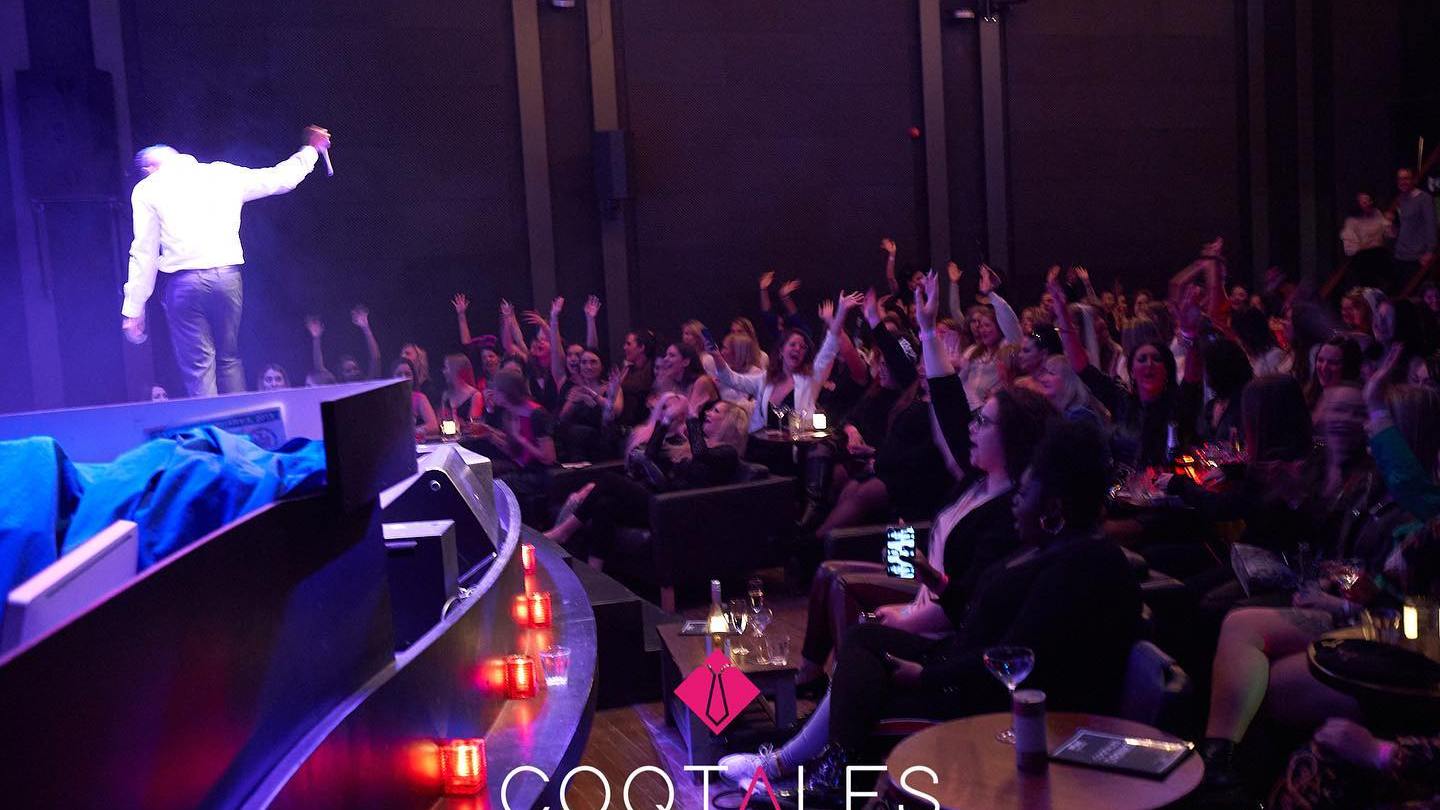 a group of people sitting at a table in front of a stage